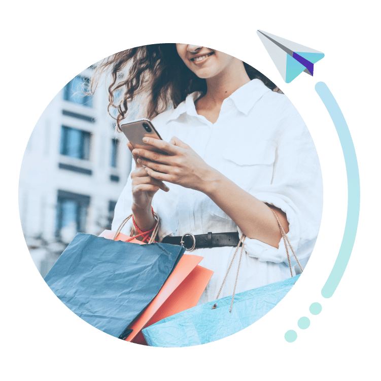 imagen de mujer mirando el m&oacute;vil con bolsas de la compra